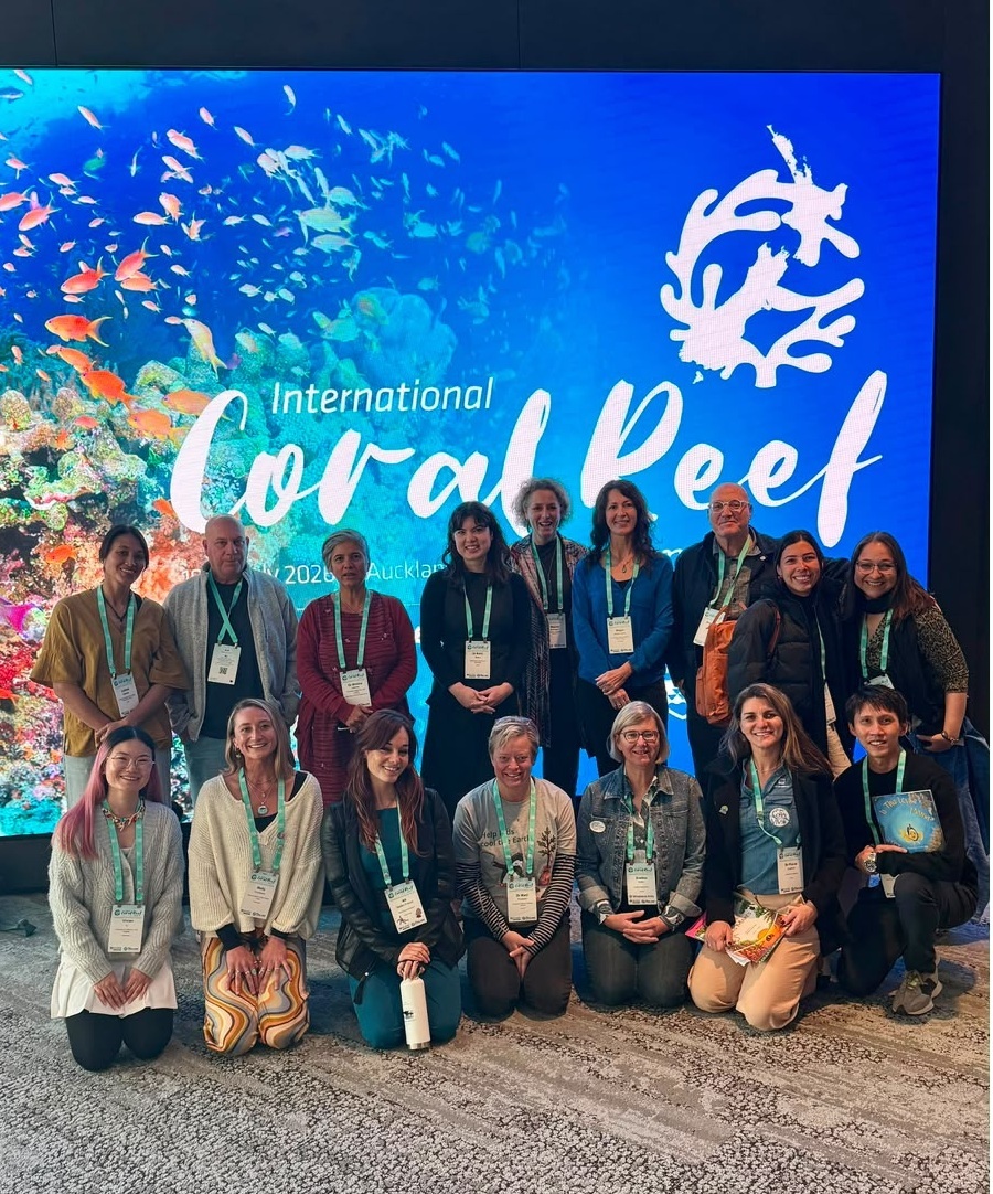 Integrantes e parceiros do Projeto Coral Vivo reunidos em frente ao painel do ICRS 2026.